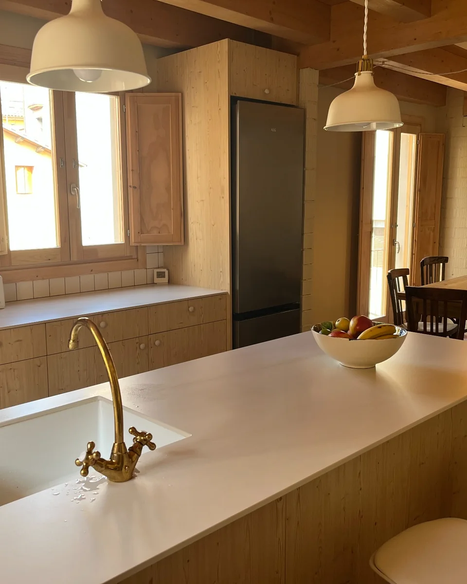 Interior de Can Fèlix amb cuina equipada, illa i taula del menjador